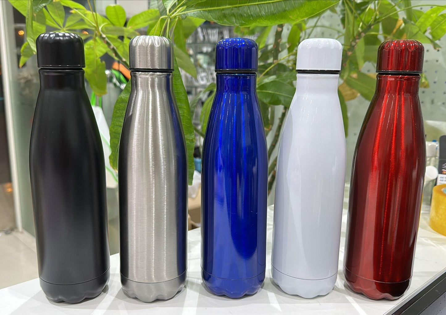 Set of five colorful Thermal Bottle 500ml bottles in black, silver, blue, white, and red on a white surface.